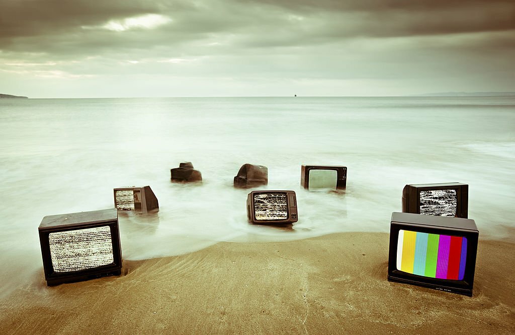 Lots of televisions Not Detected Signal on an early morning beach.